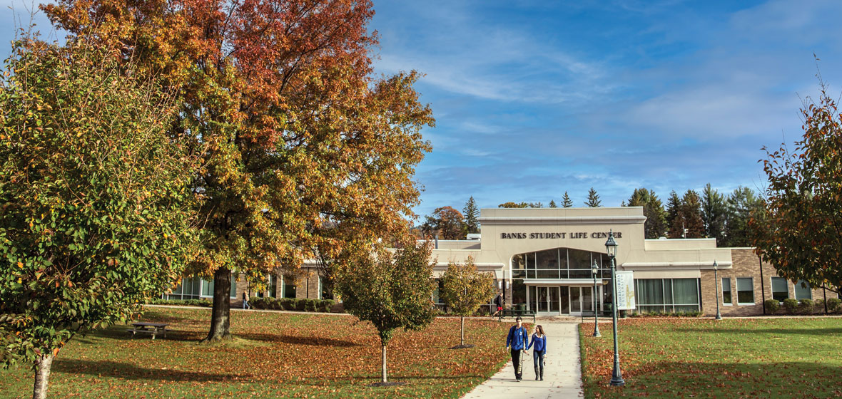 Banks student life center in the fall, two students walking outside