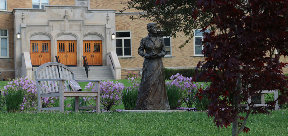 bench and a statue outside of campus building