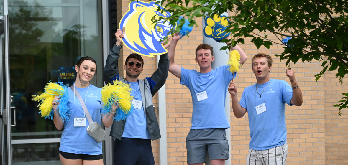 students dressed in school colors holding their team signs